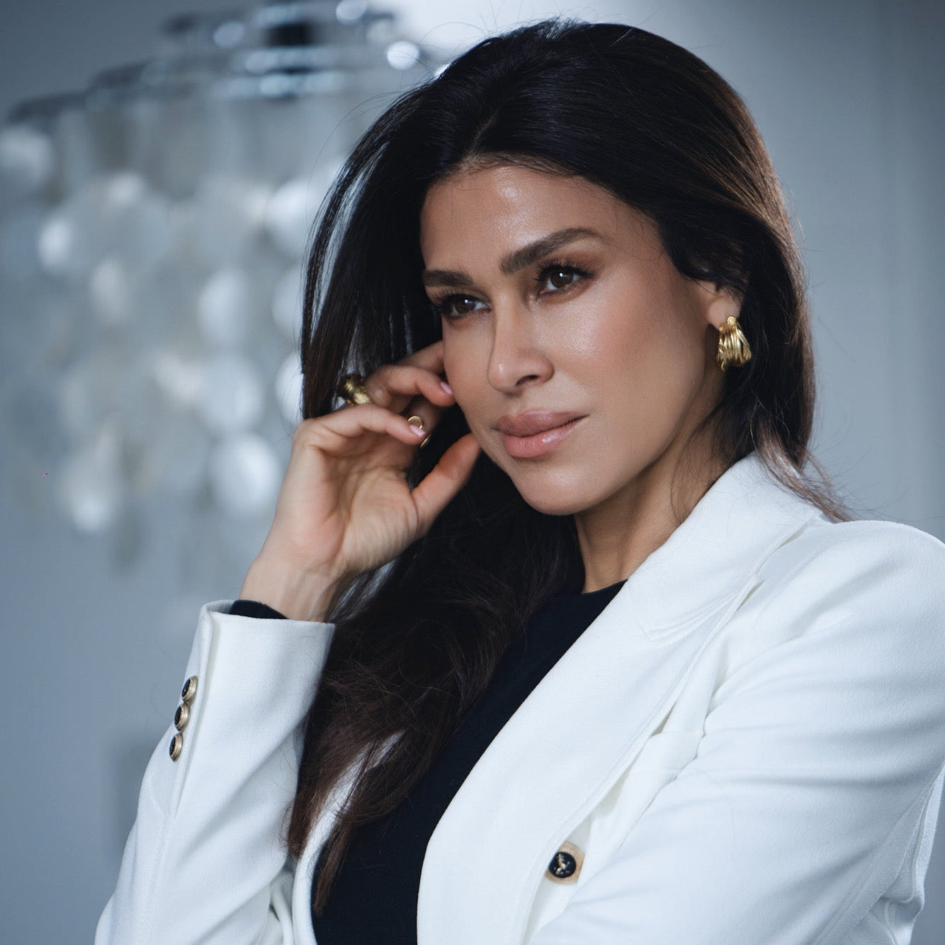 Woman in a white blazer wearing gold chunky layered hoop earrings at RM Kandy
